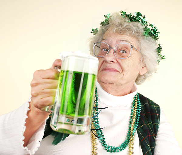 senior woman drinking green beer