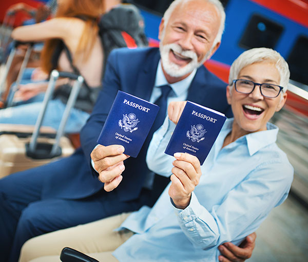 a senior couple in airport displaying their passports