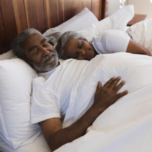 Close-up of a senior African American couple sleeping together in bedroom at home